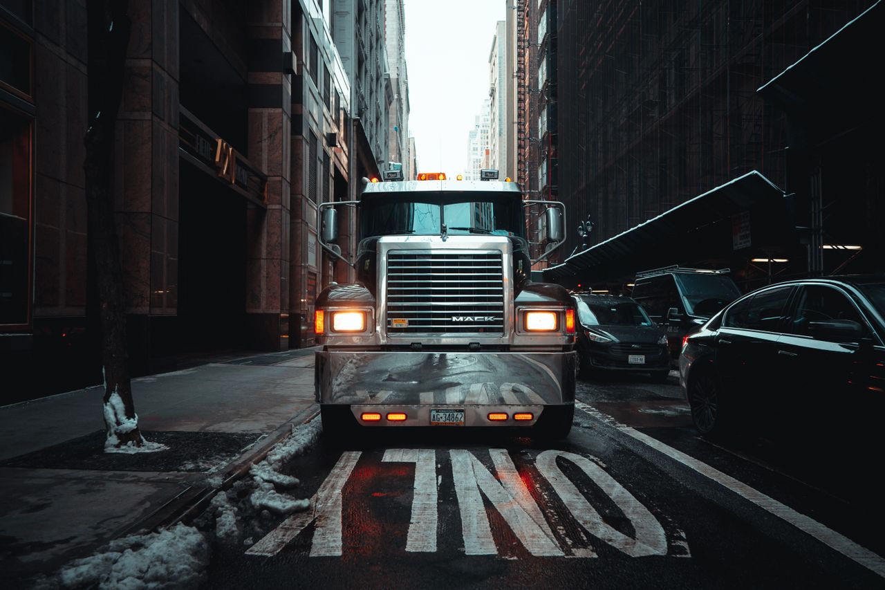 Front view of a truck on the streets of New York City in an urban, winter setting.