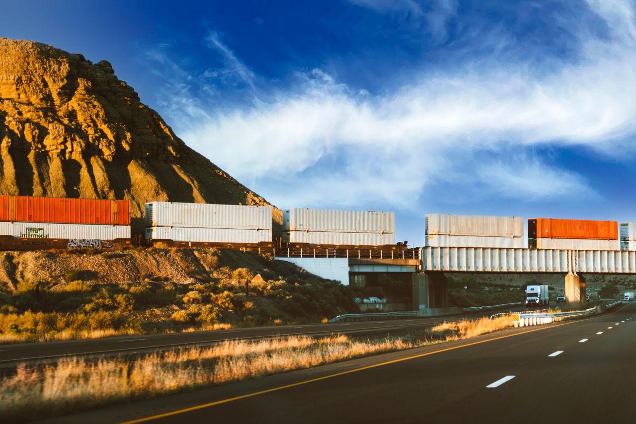 Freight train crossing through Nevada desert landscape with a clear blue sky, capturing the essence of transportation.