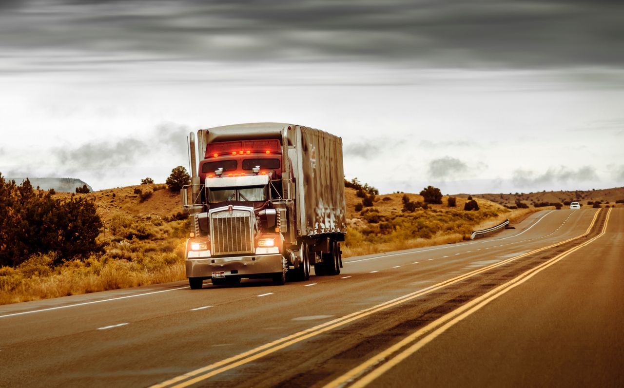 A large truck driving on a desert highway in Nevada, USA. Perfect for transportation themes.